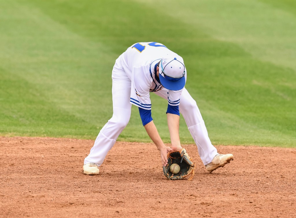 Youth baseball player fielding a ground ball on the infield