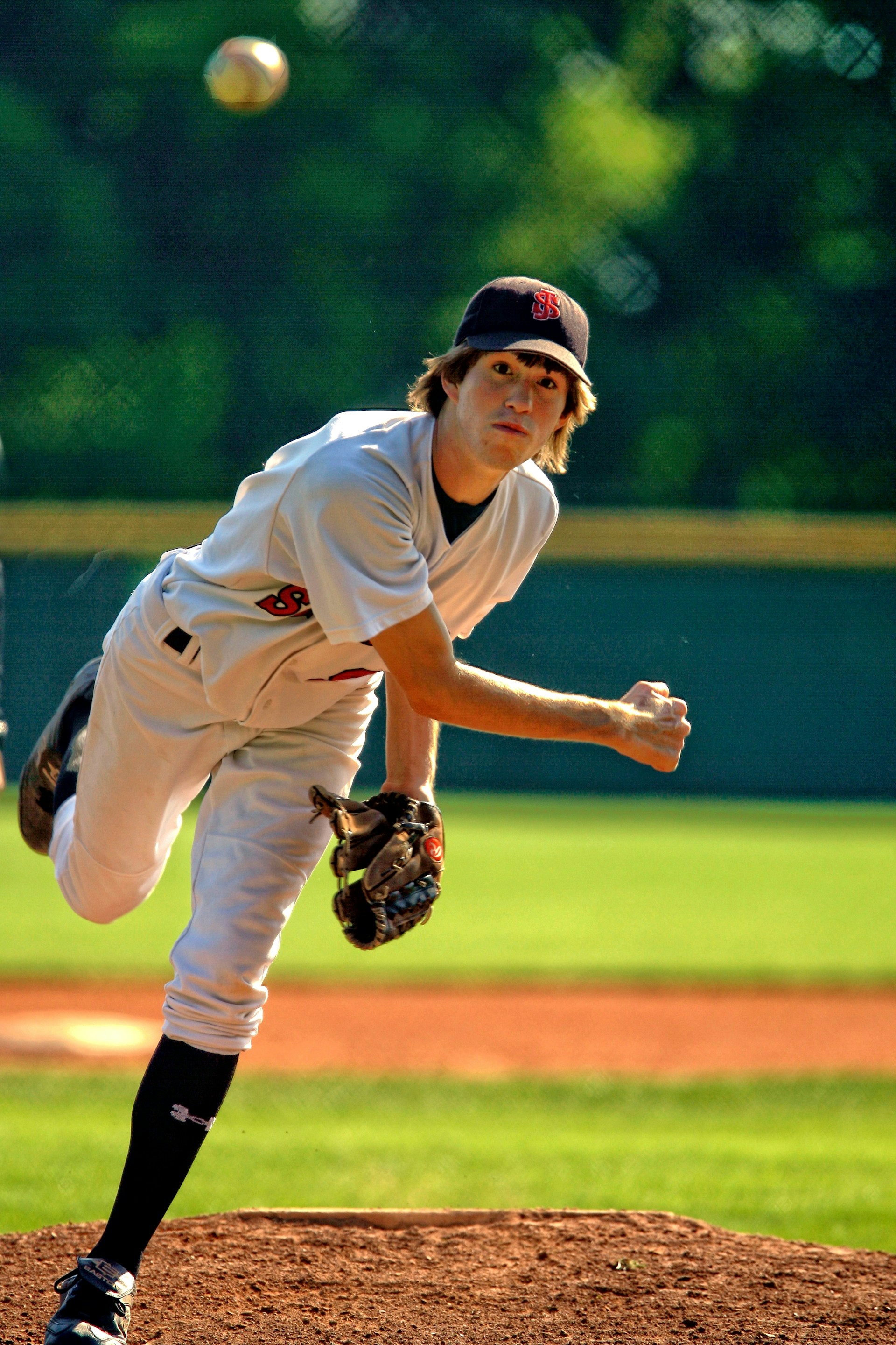 High school baseball pitcher releasing a fastball during a game — photo by Unsplash